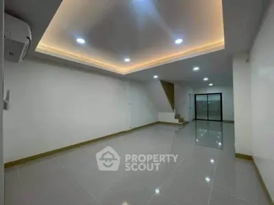 Spacious modern living room with recessed lighting and sleek tile flooring