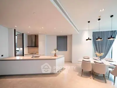 Luxurious open-plan kitchen and dining area with modern lighting and elegant decor.