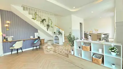Stylish open-plan living room with modern decor and elegant staircase