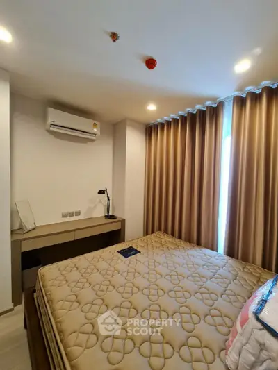 Cozy bedroom with modern furnishings and air conditioning in a stylish apartment.