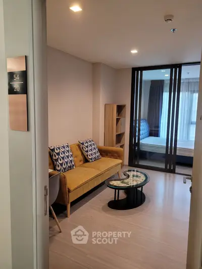 Modern living room with stylish decor and sliding glass doors leading to a bedroom, perfect for urban living.