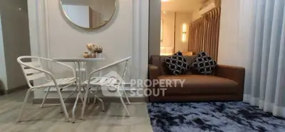 Modern living room with stylish decor, featuring a cozy sofa and elegant dining set.
