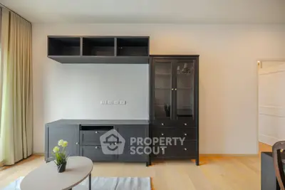 Modern living room with sleek black cabinetry and light wood flooring