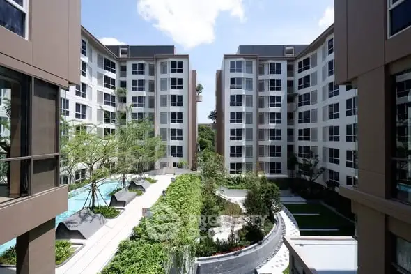 Modern apartment complex with lush garden and pool view