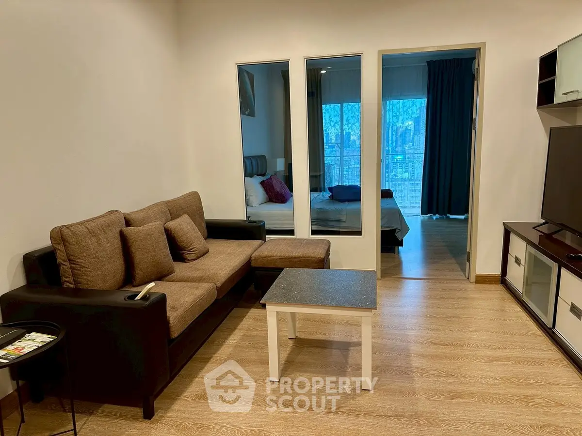 Modern living room with cozy sofa and view into bedroom, perfect for urban living.