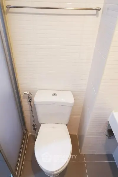 Compact modern bathroom with sleek white tiles and toilet