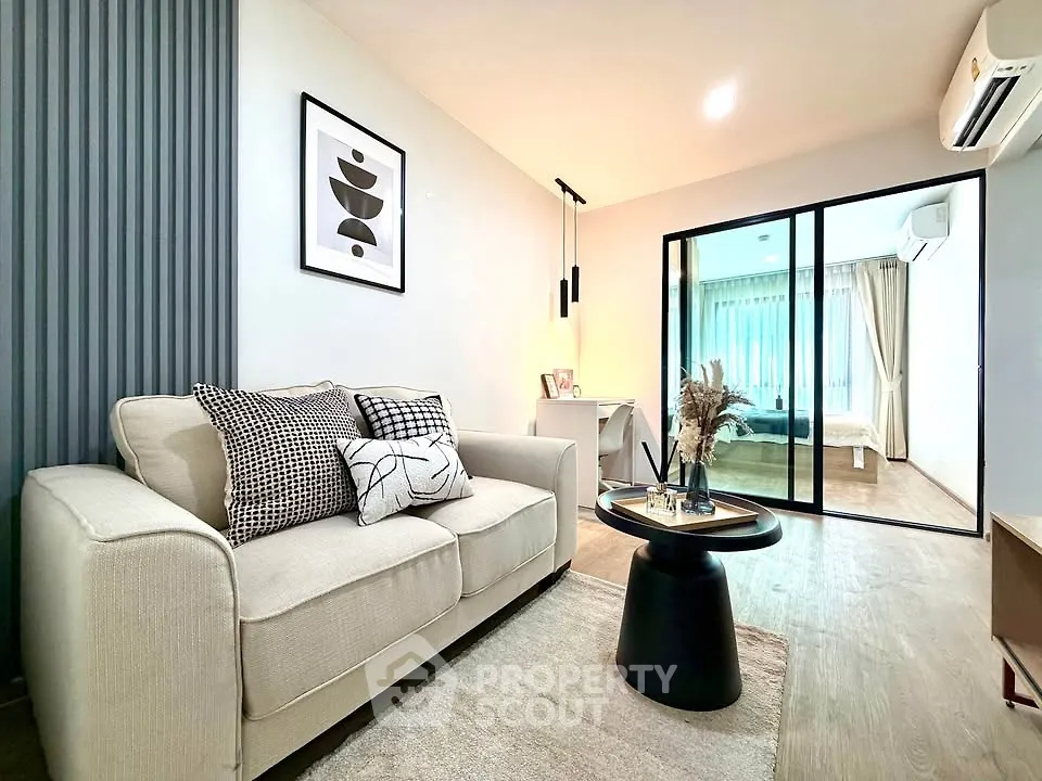 Modern living room with stylish decor and view into cozy bedroom