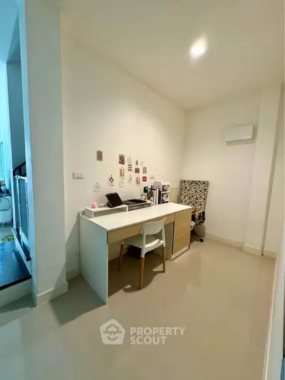 Modern study area with sleek desk and chair in bright interior space.