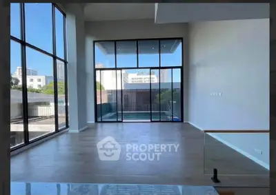 Spacious modern living room with floor-to-ceiling windows and pool view