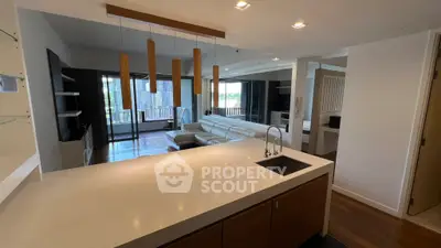 Modern open-plan living room with sleek kitchen and stylish lighting