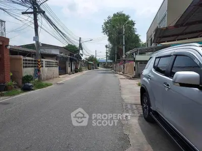 Quiet residential street with parked SUV and utility poles, ideal for peaceful living.