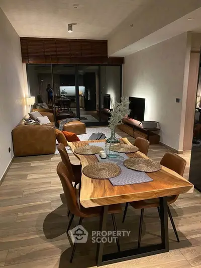 Stylish open-plan living and dining area with modern furnishings and warm lighting.