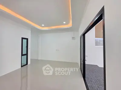 Spacious modern living room with sleek lighting and large glass doors