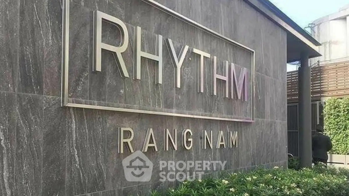 Modern building exterior with stylish signage at Rhythm Rangnam, showcasing contemporary architecture.