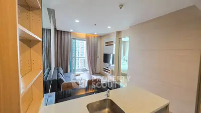Modern open-plan living room with sleek kitchen and cozy seating area, perfect for urban living.