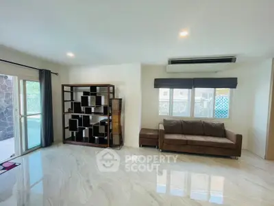 Spacious living room with modern decor and large windows for natural light.