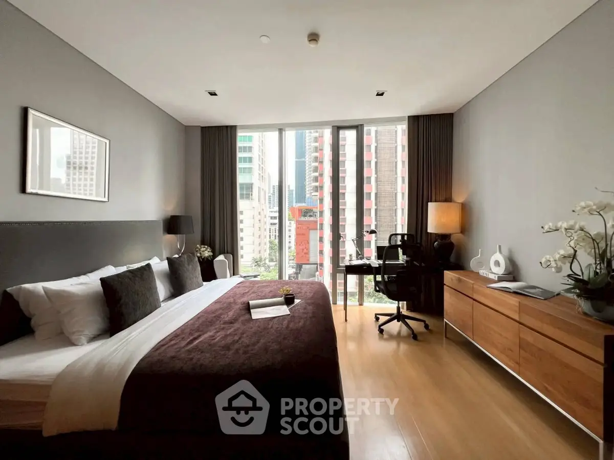 Luxurious bedroom with city view, modern decor, and workspace