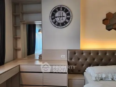 Modern bedroom with stylish decor and tufted headboard, featuring a wall clock and built-in storage.