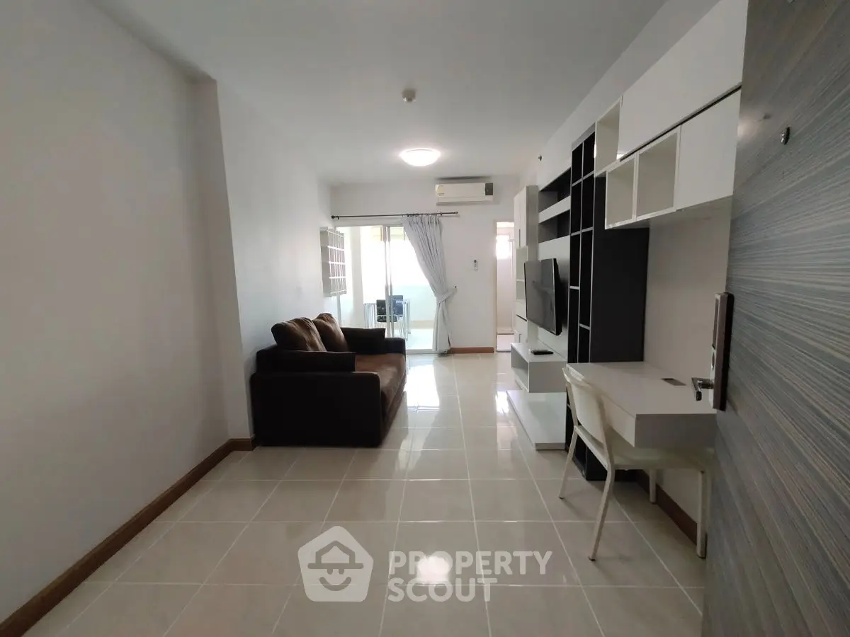 Modern living room with sleek furniture and open layout, featuring a cozy sofa and stylish shelving unit.