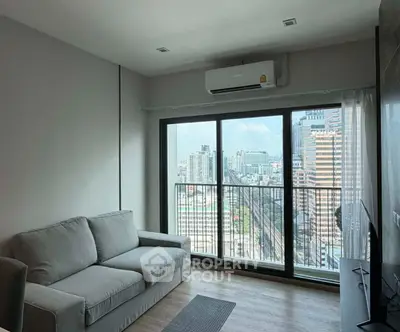 Modern living room with city view from large windows and cozy sofa.