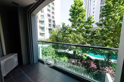 Spacious balcony with lush garden view in modern apartment complex