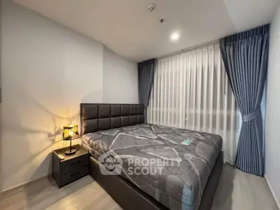 Modern bedroom with stylish decor and natural light, featuring a comfortable bed and elegant curtains.