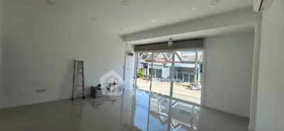 Spacious empty room with glossy floor and large window offering natural light