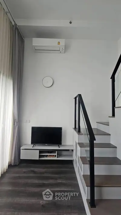 Modern living room with sleek staircase and minimalist decor