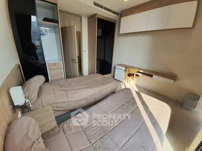 Modern twin bedroom with sleek design and ample natural light, featuring built-in storage and workspace.