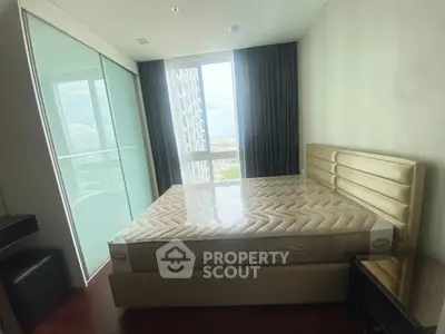 Modern bedroom with large window and stylish bed in a high-rise apartment.