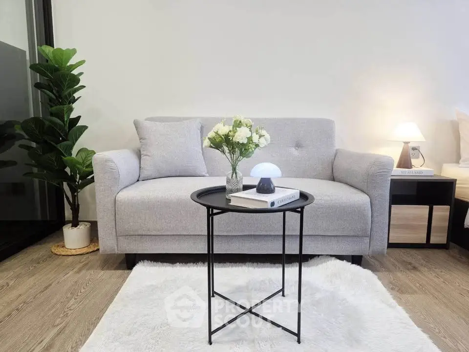 Modern living room with stylish gray sofa, elegant decor, and cozy lighting on wooden flooring.
