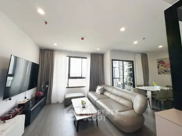 Modern living room with sleek furniture and large windows for natural light.