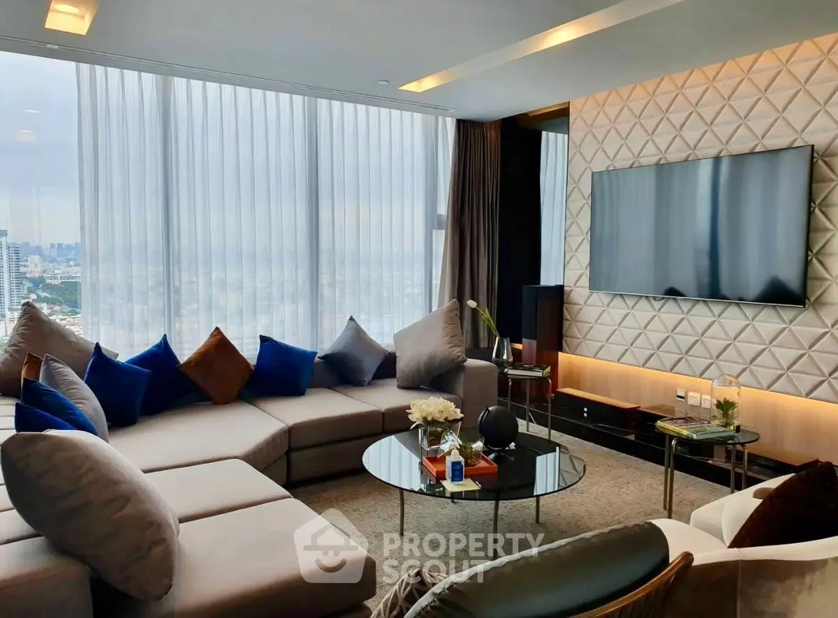 Luxurious living room with modern decor and stunning city view, featuring plush seating and a large flat-screen TV.