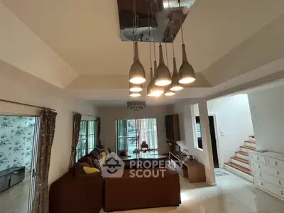 Spacious living room with modern lighting and cozy seating area