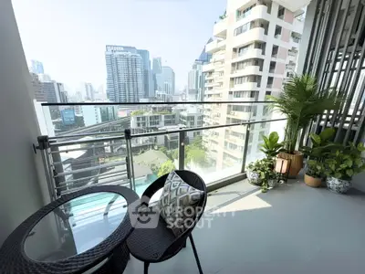 Modern balcony with city view, stylish furniture, and lush plants in a high-rise apartment.