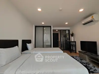 Modern bedroom with two beds, air conditioning, and TV in a stylish apartment.