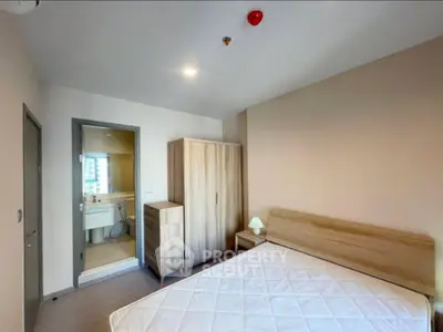Modern bedroom with ensuite bathroom and wooden furniture in a stylish apartment.