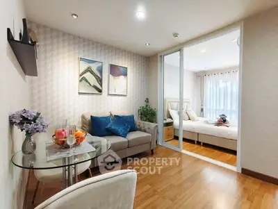 Cozy living room with modern decor and adjacent bedroom in open layout apartment.