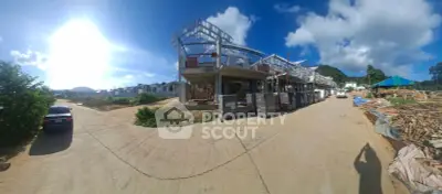 Panoramic view of a construction site with clear blue sky and surrounding landscape.