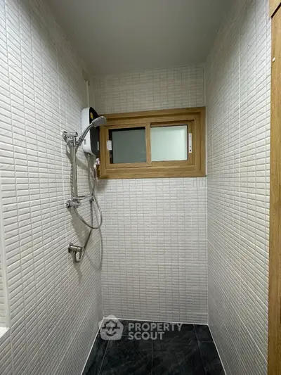 Modern bathroom with sleek shower and textured white tiles