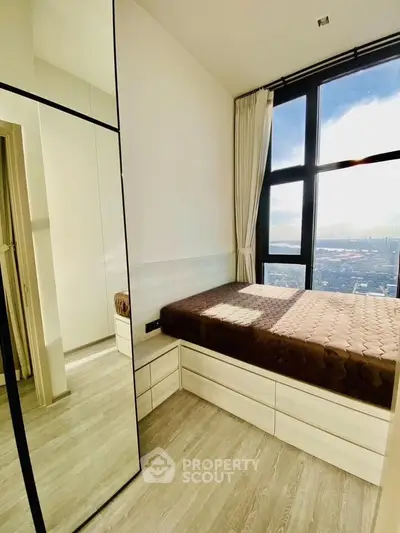 Modern bedroom with floor-to-ceiling windows offering stunning city views and ample natural light.