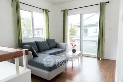 Bright and airy living room with modern sectional sofa and large windows overlooking balcony.