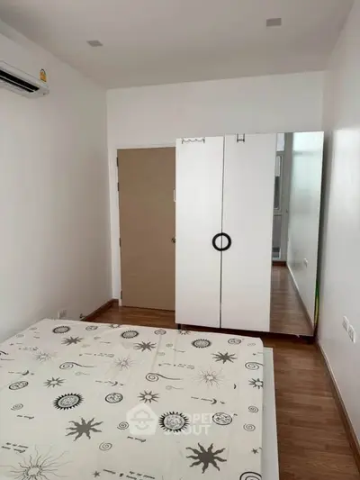 Cozy bedroom with modern wardrobe and air conditioning in a minimalist design.