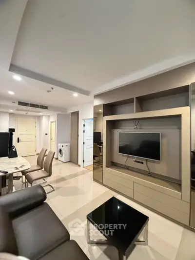 Modern living room with sleek furniture and built-in TV unit in a stylish apartment.