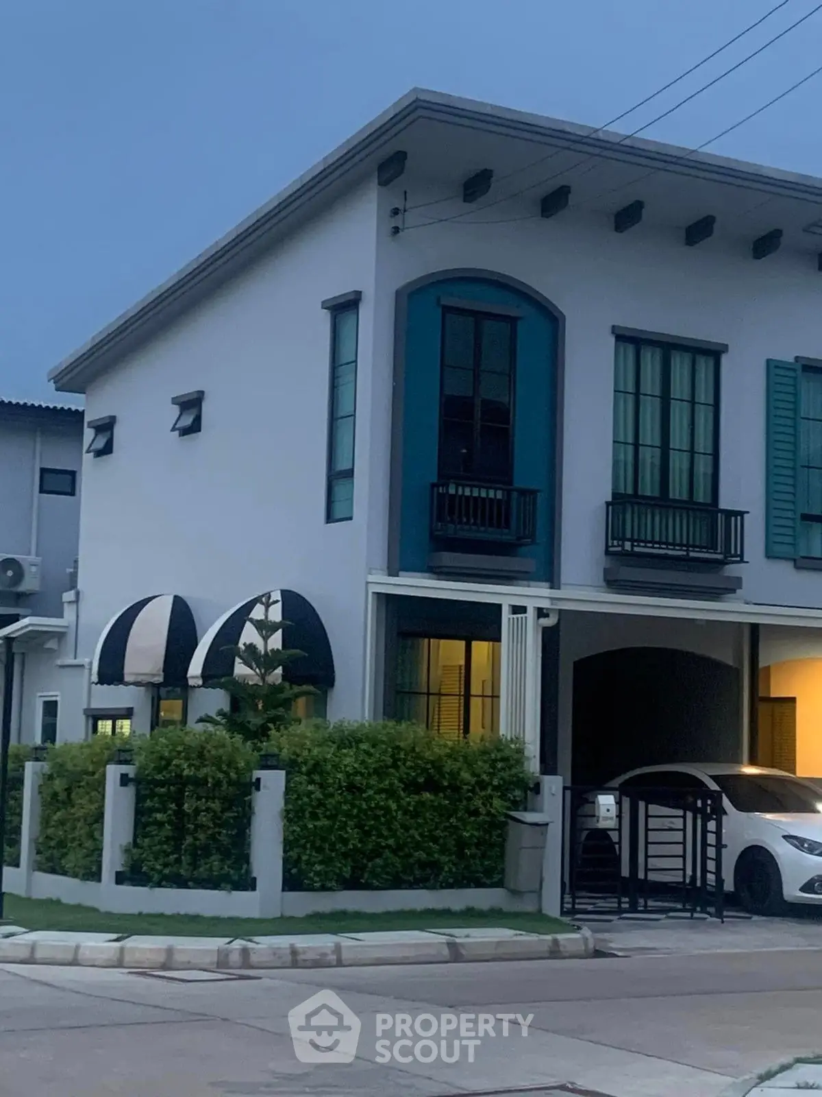 Charming two-story house with modern design and carport in a serene neighborhood.