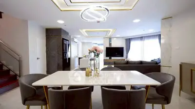 Luxurious open-plan living and dining area with modern decor and elegant lighting.