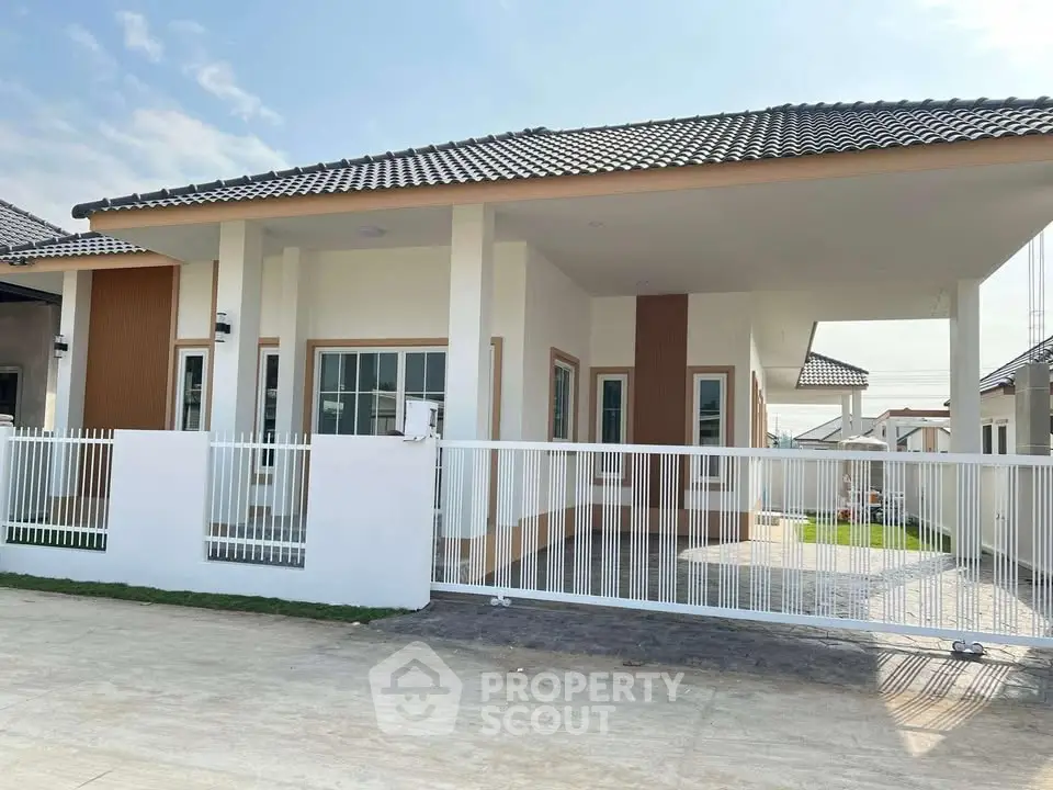Modern single-story house with spacious driveway and sleek design in a serene neighborhood.