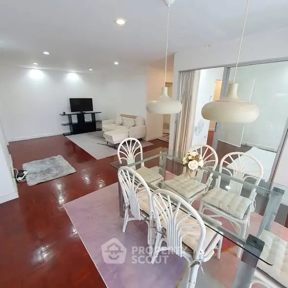 Spacious open-plan living and dining area with modern decor and hardwood floors.