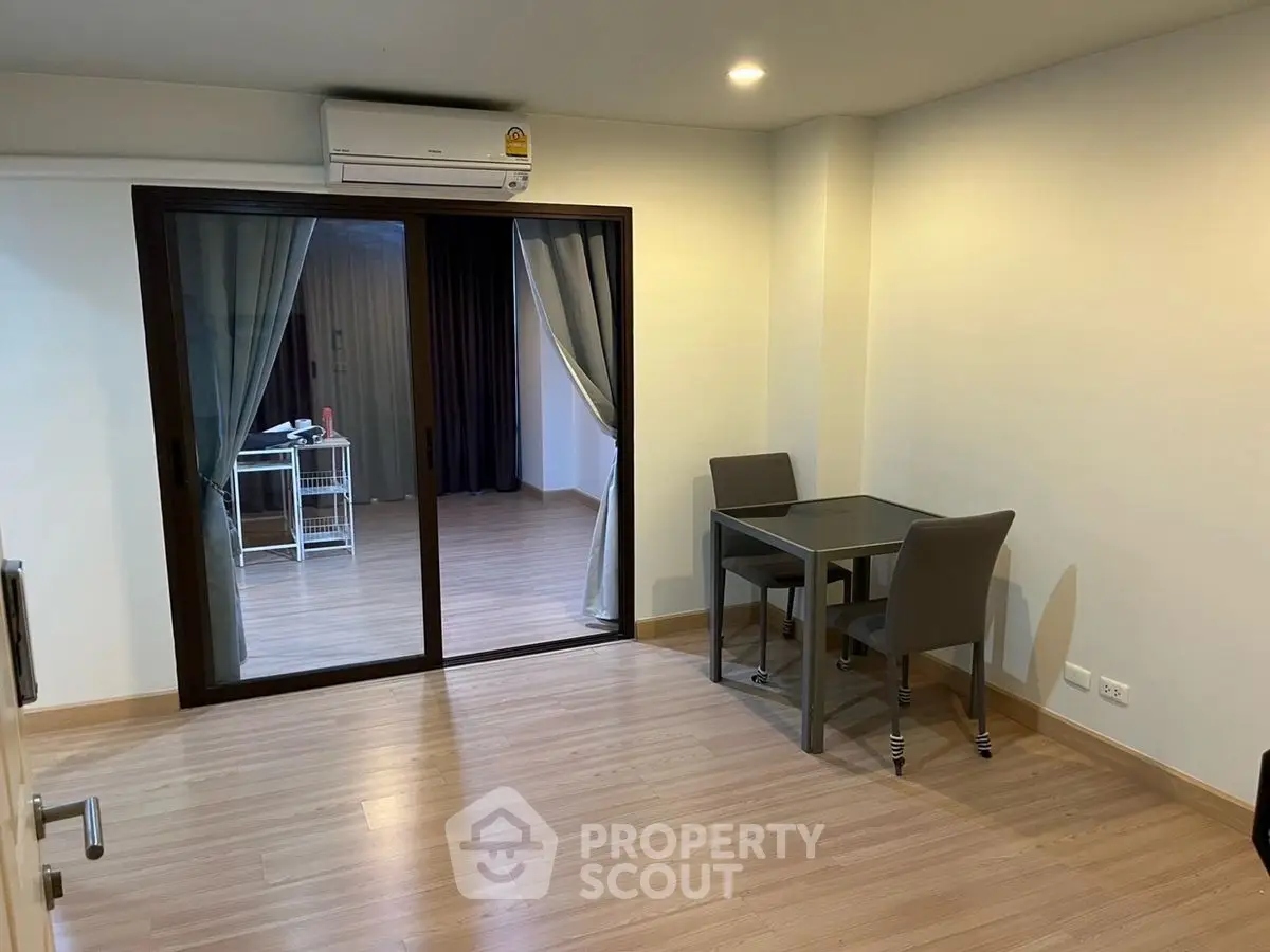 Modern apartment with open layout and sliding glass doors leading to balcony.