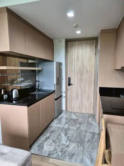 Modern kitchen with sleek cabinetry and stainless steel appliances in a stylish apartment.